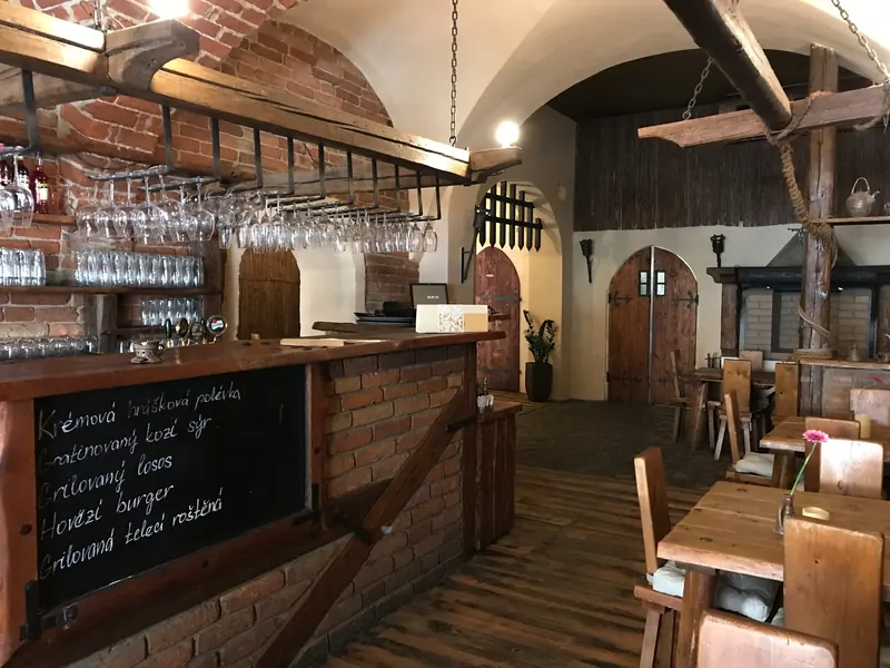 Bar pod cihlovou klenbou s křídovou tabulí