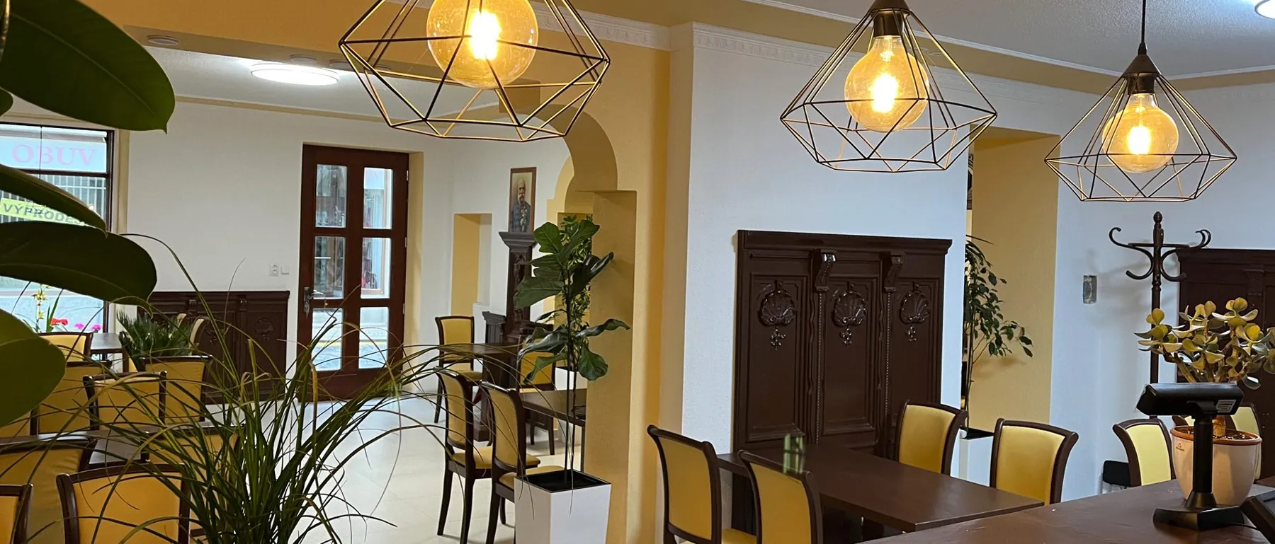 Restaurace VT6 se závěsnými lampami a zelenými rostlinami